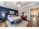 Spacious primary bedroom featuring a tray ceiling, dark accent wall, and large windows at 5010 Towneship Creek Rd, Roswell, GA 30075
