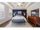 Spacious primary bedroom featuring a tray ceiling, dark accent wall, and large windows at 5010 Towneship Creek Rd, Roswell, GA 30075