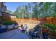 Landscaped backyard featuring modern privacy fence, patio, chairs, and plantings at 5010 Towneship Creek Rd, Roswell, GA 30075