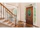 Home foyer featuring hardwood floors, staircase with iron railings and wood front door at 5145 Southlake Dr, Alpharetta, GA 30005