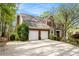 Side view of brick home featuring an attached two-car garage and long driveway at 5145 Southlake Dr, Alpharetta, GA 30005