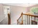 Hallway with chandelier and arched window with black wrought iron accents on the stairway at 5145 Southlake Dr, Alpharetta, GA 30005