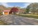 Ranch-style house with red metal roof, attached garage, covered porch, and a long concrete driveway at 6690 Pine Ridge Cir, Cumming, GA 30041