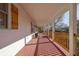 Charming front porch with white pillars, stained wood flooring and railings, and wood-stained window shutters at 6690 Pine Ridge Cir, Cumming, GA 30041