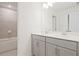 Bright bathroom with double vanity with gray cabinetry and a tub/shower combo with elegant, neutral tile at 4212 Adler Cir, Buford, GA 30519