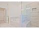 A luxurious bathtub and frameless glass shower showcasing elegant tilework and a built-in niche, perfect for relaxation at 4212 Adler Cir, Buford, GA 30519