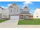 Charming two-story home with a brick and gray facade, spacious garage, and a welcoming front porch at 4212 Adler Cir, Buford, GA 30519