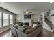 Spacious living room featuring a fireplace, large windows, and staircase access at 4685 Orchard View Way, Cumming, GA 30028