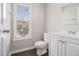 Clean half bathroom with white vanity, toilet, and window with blinds for natural light at 1577 Linksview Close, Stone Mountain, GA 30088