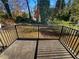 Back porch with wrought iron railing overlooking a wooded lot and underbrush at 3301 Henderson Mill Rd # 1, Atlanta, GA 30341