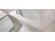 Close up of a white corner bathtub, featuring tile surround and white cabinets nearby at 3301 Henderson Mill Rd # 1, Atlanta, GA 30341