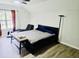 Bright bedroom featuring wood floors, a ceiling fan, and a comfortable lounge chair at 5980 Sherwood Trce, Lithonia, GA 30038