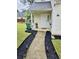 Inviting home showcasing a welcoming walkway, complemented by lush landscaping and manicured lawn at 5980 Sherwood Trce, Lithonia, GA 30038