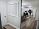 Hallway leading to kitchen with wood floors, neutral paint, and modern light fixtures at 5980 Sherwood Trce, Lithonia, GA 30038