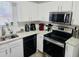 Modern kitchen with stainless steel appliances, granite countertops, and white cabinetry at 5980 Sherwood Trce, Lithonia, GA 30038