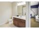Neutral bathroom with a dark wood vanity and access to a room with colorful wall decorations at 6463 Century Park Se Pl, Mableton, GA 30126