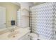 Bright bathroom with a single vanity, a tub-shower combo with a patterned curtain, and floating shelves at 6463 Century Park Se Pl, Mableton, GA 30126