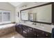 Bathroom features a large framed mirror, double vanity with white countertop, tub, and tiled floors at 6463 Century Park Se Pl, Mableton, GA 30126