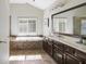 A luxurious primary bathroom features a soaking tub, a large mirror, and custom cabinets at 6463 Century Park Se Pl, Mableton, GA 30126
