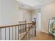 Upstairs hallway features wooden railing and a view to the main bedroom at 6463 Century Park Se Pl, Mableton, GA 30126
