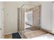 Glass-enclosed shower in bathroom with beige tiled walls and a window for natural light at 6463 Century Park Se Pl, Mableton, GA 30126