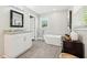 Modern bathroom with a granite countertop vanity, a sleek mirror, and a luxurious soaking tub at 100 Charlotte Sw Dr, Mableton, GA 30126