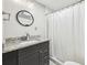 Modern bathroom features a vanity with granite countertop, round mirror, and shower with curtain at 100 Charlotte Sw Dr, Mableton, GA 30126