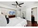 Bright bedroom featuring dark hardwood floors, ensuite, a comfortable bed, and a modern ceiling fan at 100 Charlotte Sw Dr, Mableton, GA 30126