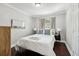 Cozy bedroom featuring a comfortable bed with stylish pillows, a side table, and dark hardwood floors at 100 Charlotte Sw Dr, Mableton, GA 30126