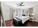 Stylish bedroom boasts dark wood floors, a comfortable bed with neutral linens, and ambient lighting at 100 Charlotte Sw Dr, Mableton, GA 30126