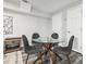 Cozy dining area with a glass table, four chairs, and a modern light fixture at 100 Charlotte Sw Dr, Mableton, GA 30126