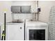 Laundry room featuring modern, front-load washer and dryer with wire storage shelf above at 100 Charlotte Sw Dr, Mableton, GA 30126