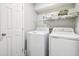 A compact laundry room equipped with modern, white front-load washer and dryer at 100 Charlotte Sw Dr, Mableton, GA 30126
