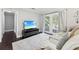 Cozy living room featuring neutral colors, a large television, and access to the back deck at 100 Charlotte Sw Dr, Mableton, GA 30126