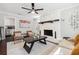 Charming living room with a stone fireplace, ceiling fan, and access to the kitchen at 100 Charlotte Sw Dr, Mableton, GA 30126