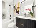 Modern bathroom features a black vanity with gold accents, decorative art, and tub with shower at 1751 Carter Cir, Atlanta, GA 30344