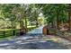 Long gated driveway leads to house, framed by lush trees and a classic fence, blending privacy with elegance at 2962 Norman Cir, Duluth, GA 30096