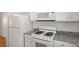 Bright kitchen featuring granite countertops, white appliances, and ample storage space, perfect for culinary enthusiasts at 4457 Watson Ridge Dr, Stone Mountain, GA 30083