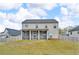 View of the rear of a two-story home with screened porch and a grassy backyard under a cloudy sky at 1105 Alaska St, Hampton, GA 30228