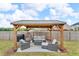 Backyard covered patio featuring outdoor seating and a grill at 1105 Alaska St, Hampton, GA 30228