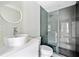 Modern bathroom featuring a sleek vanity, round mirror, and stylish glass-enclosed shower at 1276 Dahlgren Se Ln, Atlanta, GA 30316