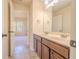 Bathroom with double vanity, tile floor, framed mirror, and wooden cabinets at 132 Windmeadow Way, Fayetteville, GA 30214