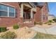 Inviting brick entrance with a covered porch and decorative landscaping at 132 Windmeadow Way, Fayetteville, GA 30214
