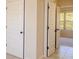 Hallway featuring multiple doors, tile flooring, and a glimpse into a bedroom with a window at 132 Windmeadow Way, Fayetteville, GA 30214