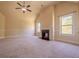 Living room features a fireplace, carpet, a ceiling fan, and many windows at 132 Windmeadow Way, Fayetteville, GA 30214