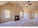 Carpeted living room with fireplace, fan, and bright windows at 132 Windmeadow Way, Fayetteville, GA 30214