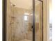 An enclosed shower with tile walls, two shower heads, and a small bench at 132 Windmeadow Way, Fayetteville, GA 30214