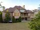 Expansive backyard featuring a lush lawn, mature trees, and covered patio at 3053 Cambridge Hill Dr, Dacula, GA 30019