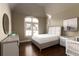 Bright bedroom featuring a cozy bed, stylish nightstands, hardwood floors, and a large window at 3053 Cambridge Hill Dr, Dacula, GA 30019
