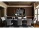 Formal dining room with a large chandelier, dark wood accents, and seating for eight at 3053 Cambridge Hill Dr, Dacula, GA 30019